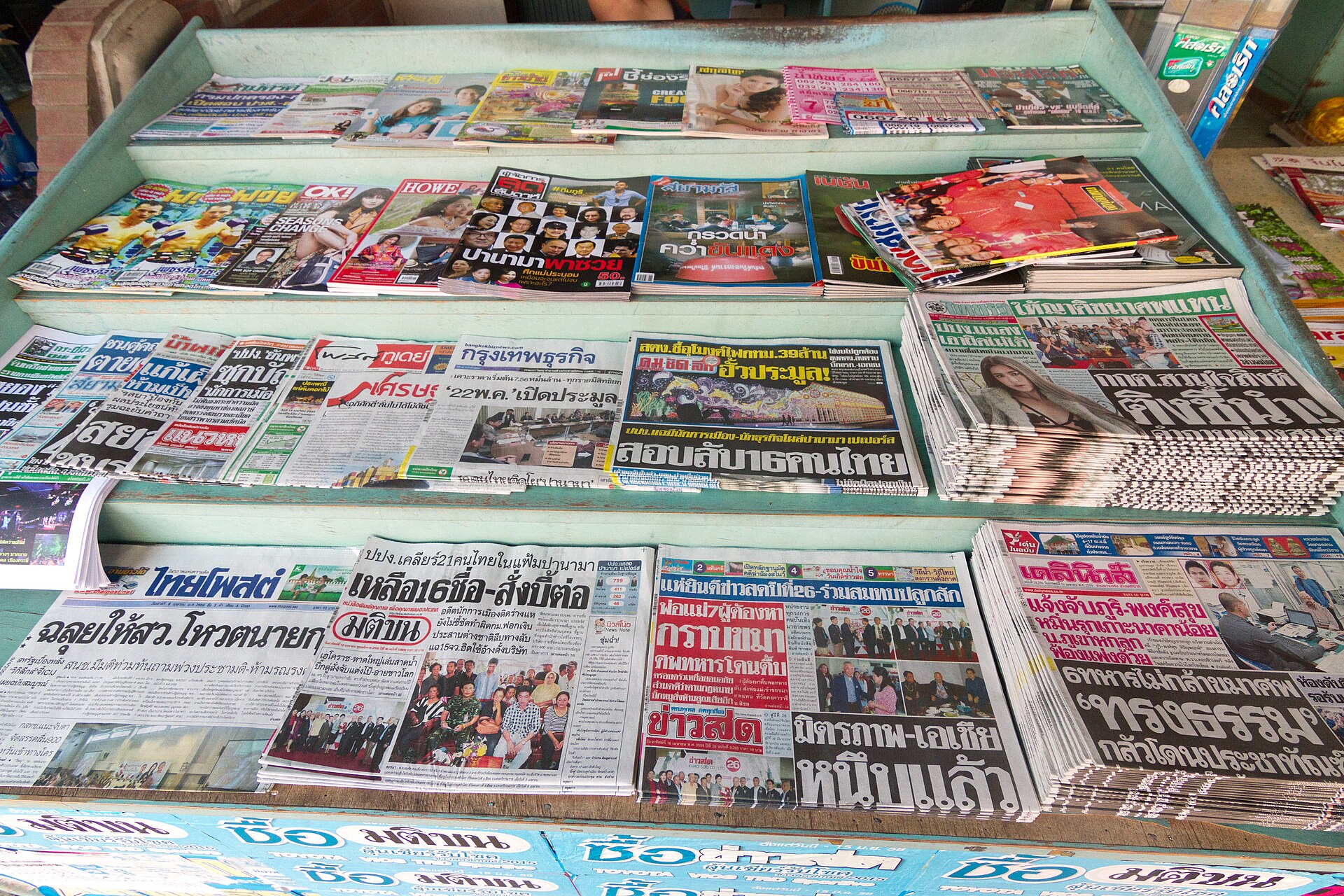 泰國甲米鎮報攤上並排陳列的各家報紙與雜誌，每份頭版選的標題都不一樣