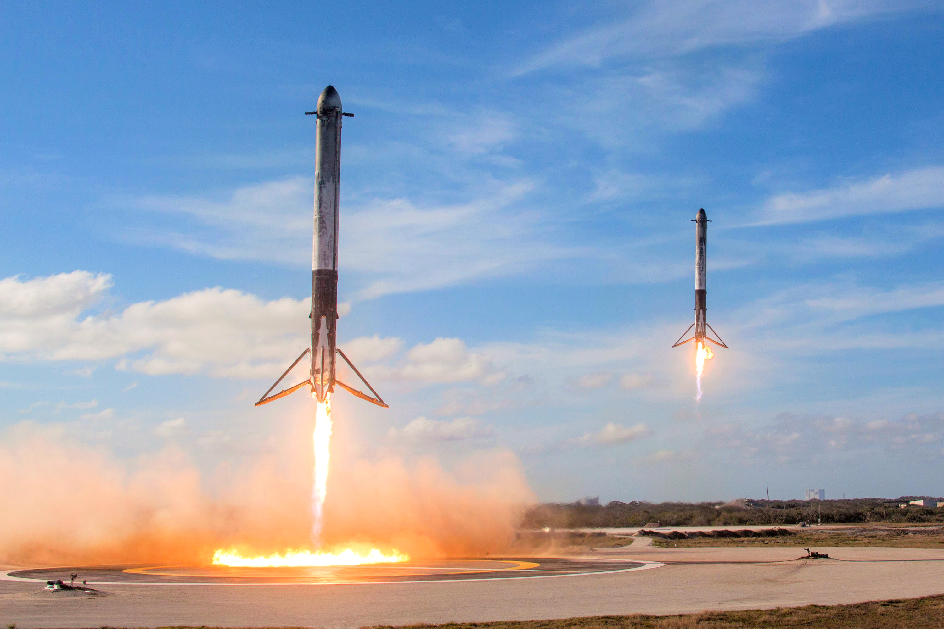 SpaceX 獵鷹重型火箭兩具助推器同時落地，象徵新一代 Roadster 在空中完成翻轉